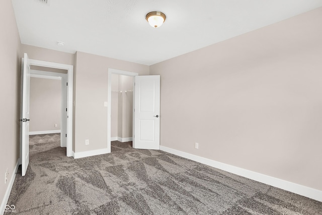 unfurnished bedroom featuring a closet and dark carpet