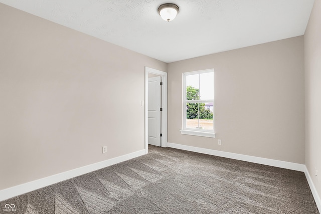 spare room featuring carpet and a textured ceiling