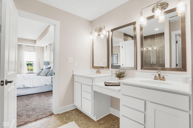 bathroom featuring tiled shower and vanity