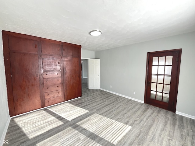 unfurnished bedroom with a textured ceiling and light hardwood / wood-style flooring