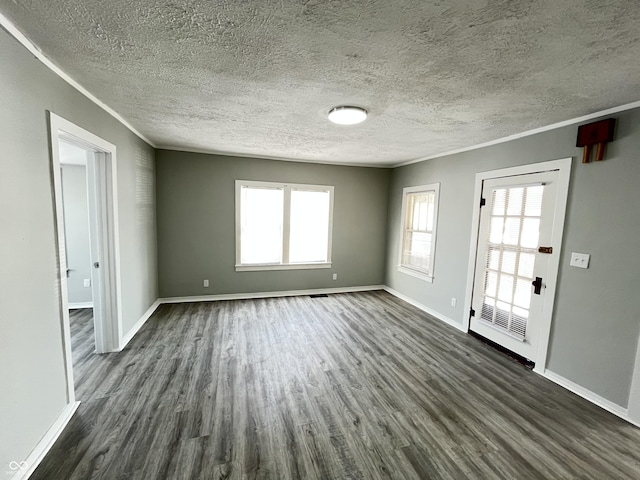 empty room featuring dark hardwood / wood-style floors, crown molding, and a textured ceiling