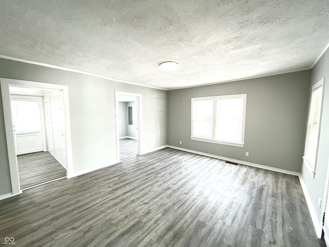 empty room featuring a textured ceiling and dark hardwood / wood-style flooring