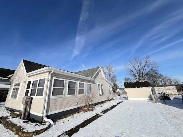 snow covered property featuring a shed