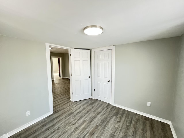 unfurnished bedroom with a closet and dark hardwood / wood-style floors