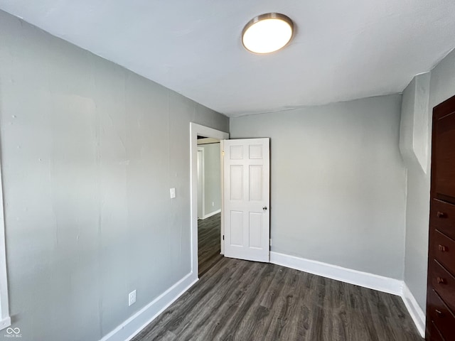 unfurnished bedroom with dark hardwood / wood-style flooring