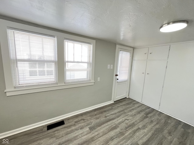 foyer entrance with hardwood / wood-style floors and a textured ceiling