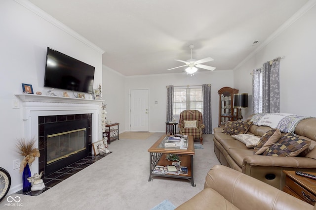 carpeted living room featuring ceiling fan, ornamental molding, and a tiled fireplace