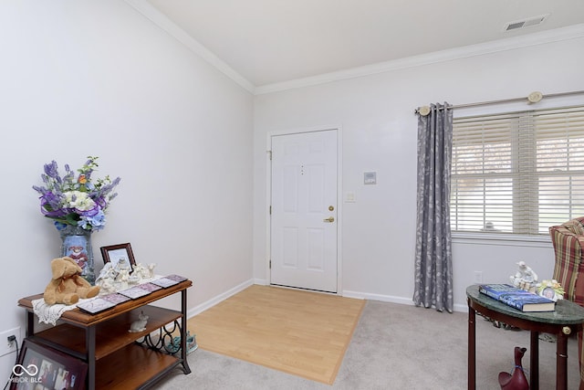 foyer entrance featuring ornamental molding and light hardwood / wood-style flooring