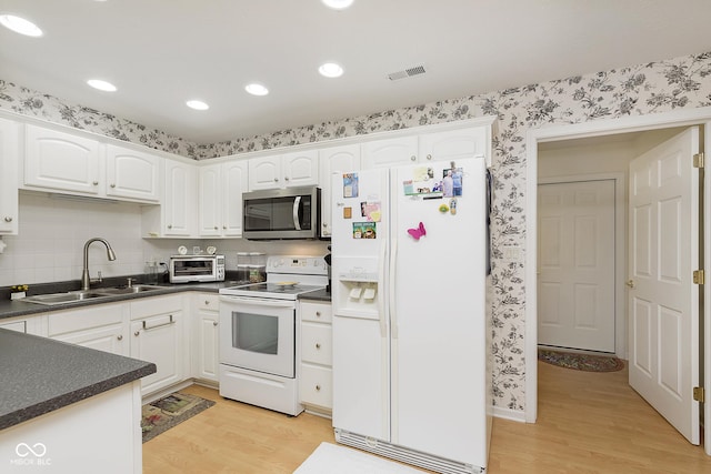 kitchen with white cabinets, light wood-type flooring, white appliances, and sink