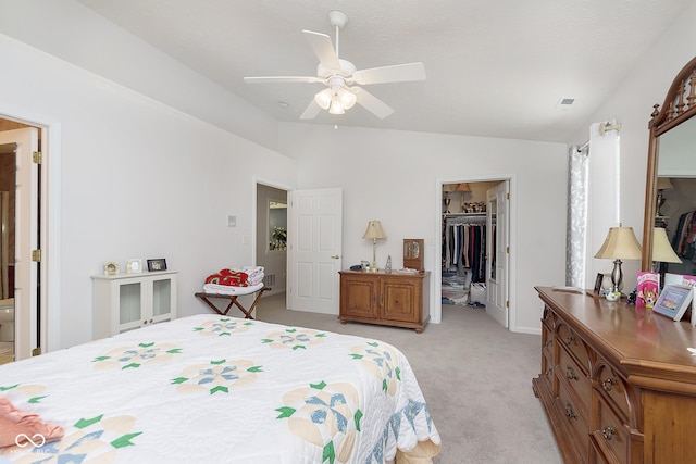 bedroom with light carpet, ceiling fan, a spacious closet, a closet, and lofted ceiling