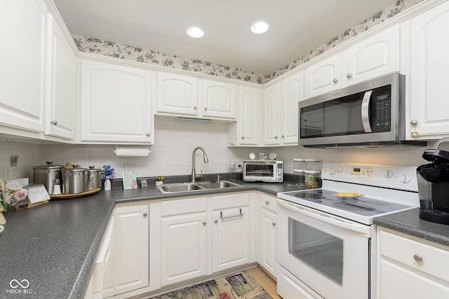 kitchen featuring decorative backsplash, sink, white cabinets, and white electric range