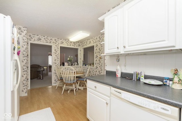 kitchen with white appliances, backsplash, light hardwood / wood-style flooring, a textured ceiling, and white cabinetry