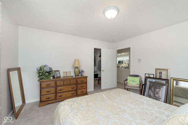 bedroom with a textured ceiling and light carpet