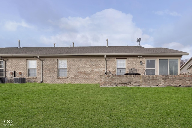 rear view of house featuring a yard and central AC unit