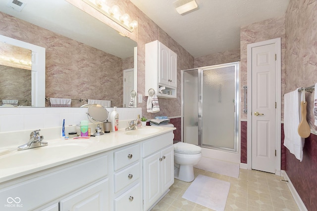 bathroom with a textured ceiling, vanity, and toilet