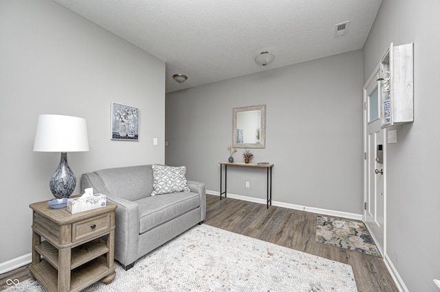 living room featuring a textured ceiling and dark hardwood / wood-style floors