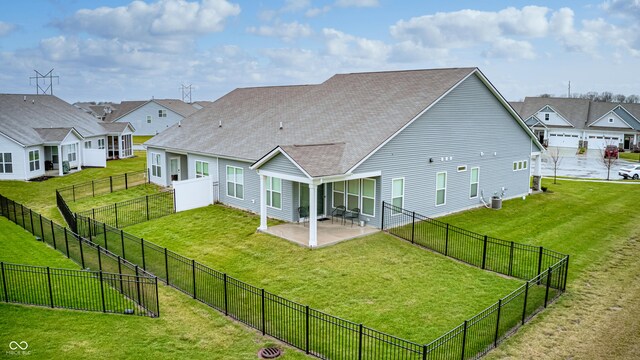 back of property with central AC, a patio area, and a lawn