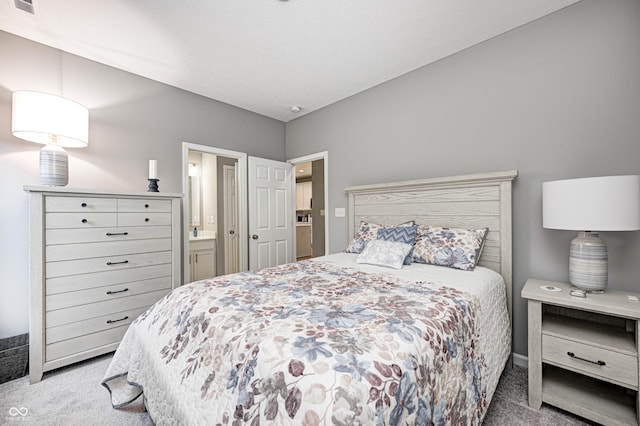 bedroom featuring light carpet and connected bathroom