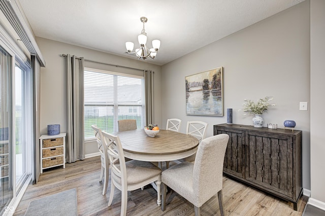 dining space featuring light hardwood / wood-style floors and an inviting chandelier