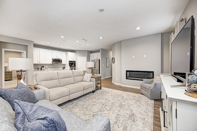 living room featuring a textured ceiling and light hardwood / wood-style flooring