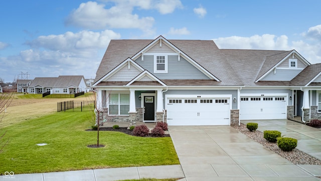 craftsman inspired home with a garage and a front lawn