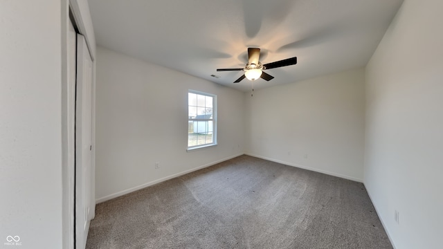 spare room with visible vents, carpet floors, baseboards, and a ceiling fan