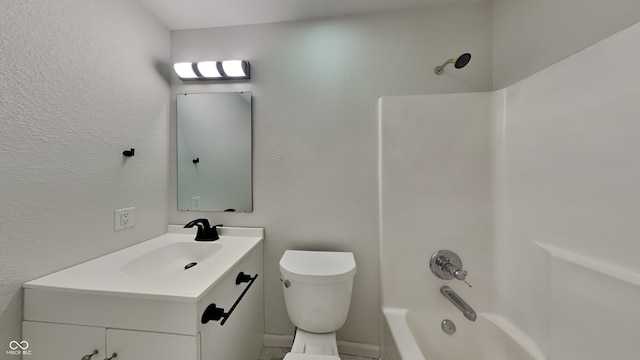 bathroom with toilet, vanity, shower / bath combination, and a textured wall