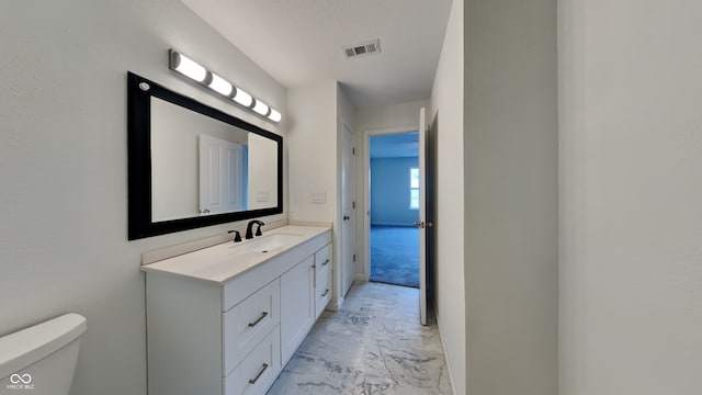 half bathroom with visible vents, marble finish floor, vanity, and toilet