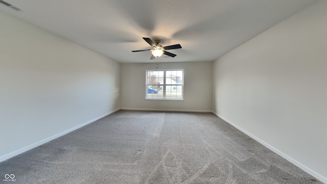 carpeted empty room with visible vents, baseboards, and ceiling fan