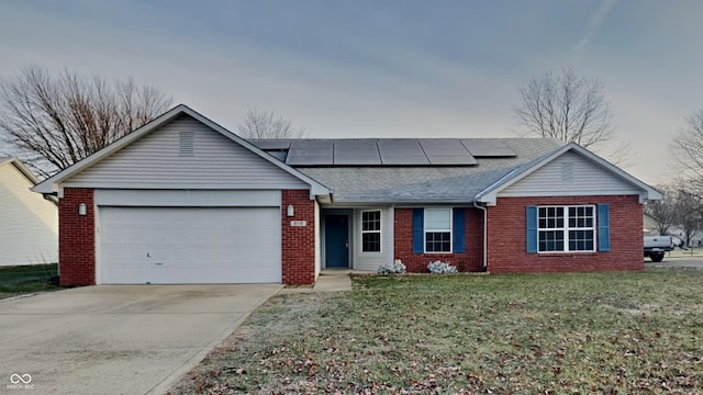 ranch-style home with a front yard, solar panels, and a garage