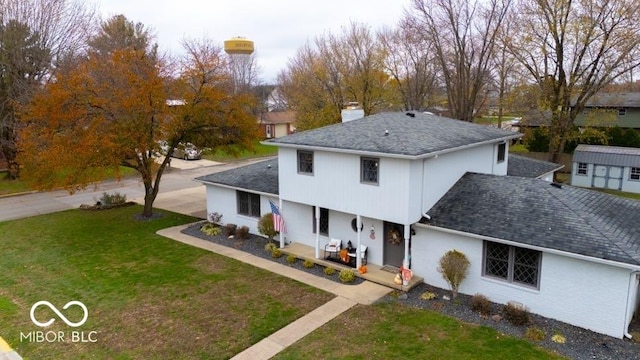 view of front of house featuring a porch, an outbuilding, and a front lawn