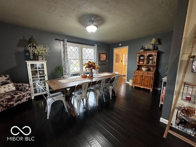 dining space with dark wood-type flooring and a textured ceiling