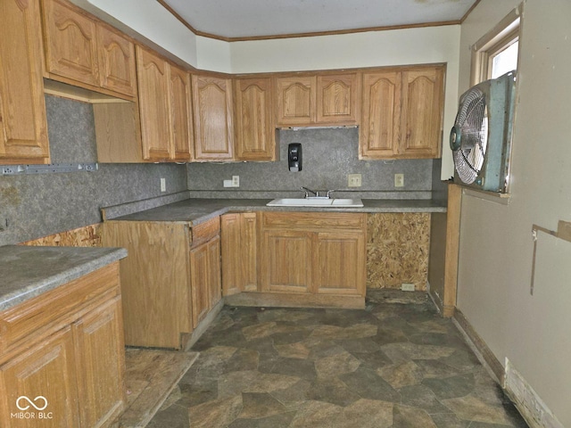 kitchen featuring decorative backsplash, crown molding, and sink