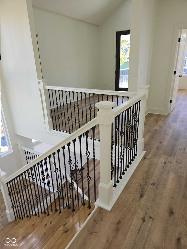 staircase featuring hardwood / wood-style floors and vaulted ceiling