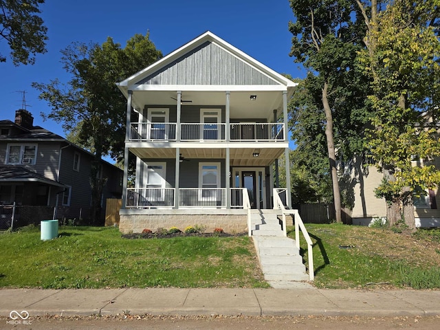 view of front of house featuring a porch, a balcony, and a front lawn