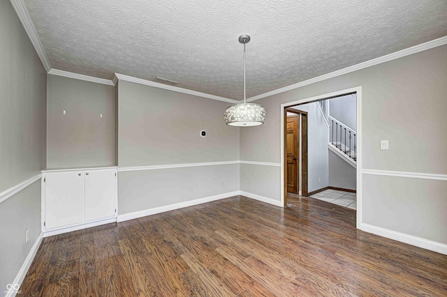 unfurnished room featuring crown molding, a textured ceiling, baseboards, and wood finished floors