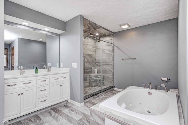 bathroom featuring plus walk in shower, a textured ceiling, and vanity