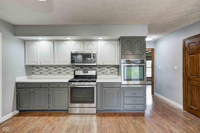 kitchen featuring light wood-type flooring, gray cabinets, stainless steel appliances, and light countertops