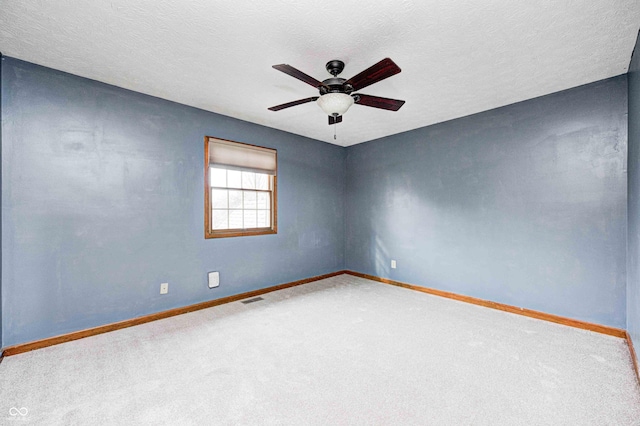 spare room with visible vents, baseboards, ceiling fan, carpet, and a textured ceiling