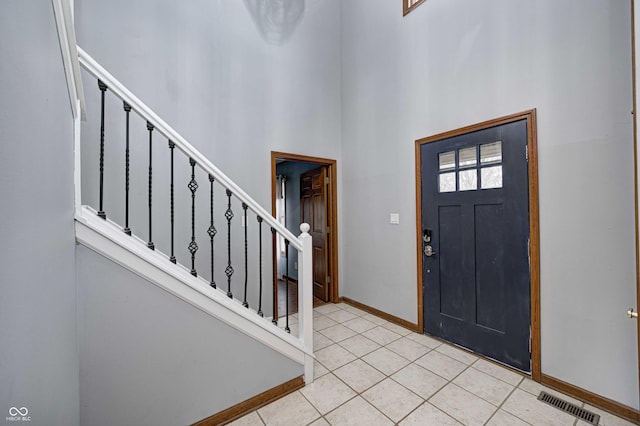 tiled foyer entrance with a towering ceiling