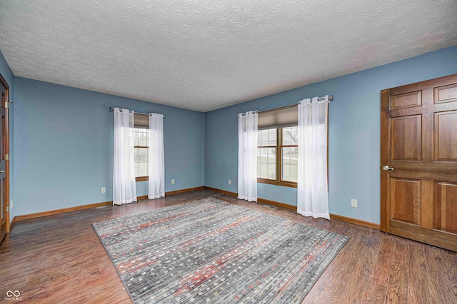 interior space with multiple windows, baseboards, and dark wood finished floors