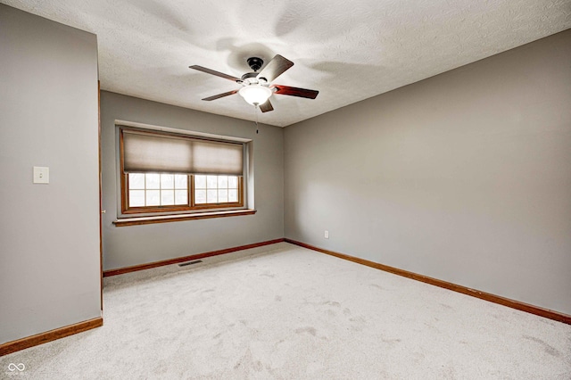 carpeted spare room with ceiling fan and a textured ceiling