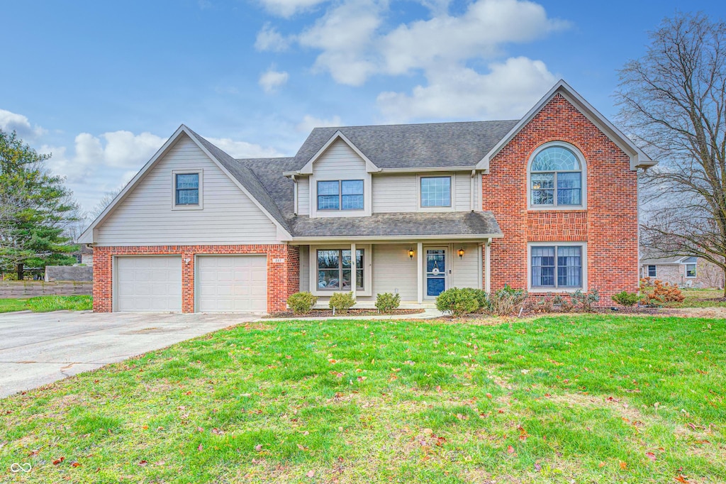 view of front of house featuring a garage, concrete driveway, brick siding, and a front lawn