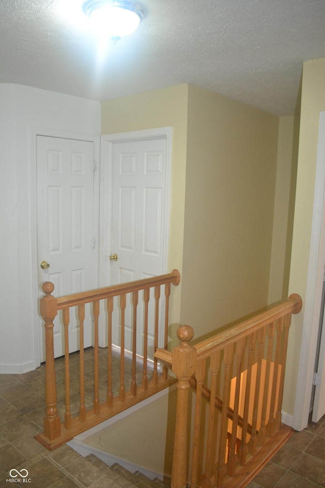 stairs with tile patterned flooring and a textured ceiling