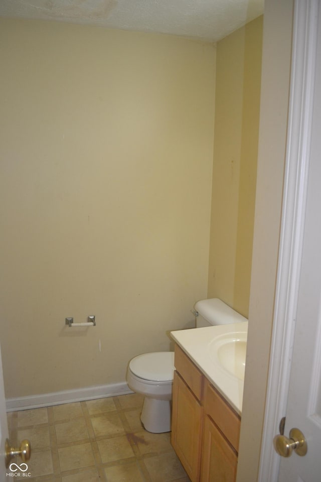 bathroom featuring a textured ceiling, vanity, and toilet