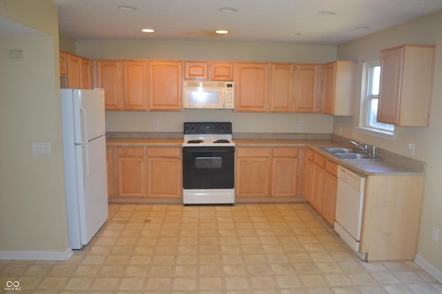 kitchen featuring light brown cabinets, white appliances, and sink