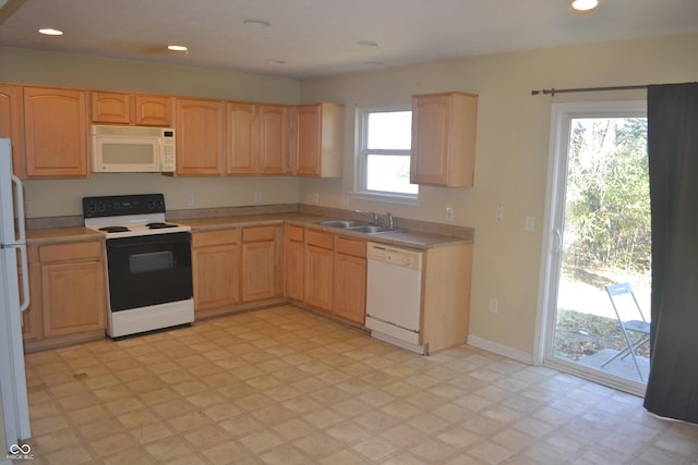 kitchen with white appliances, sink, and light brown cabinetry