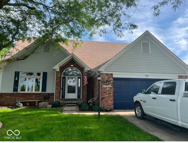 11720 Grenadier Ln, Indianapolis, IN 46229 - view of front of house featuring an attached garage, brick siding, a front lawn, and driveway