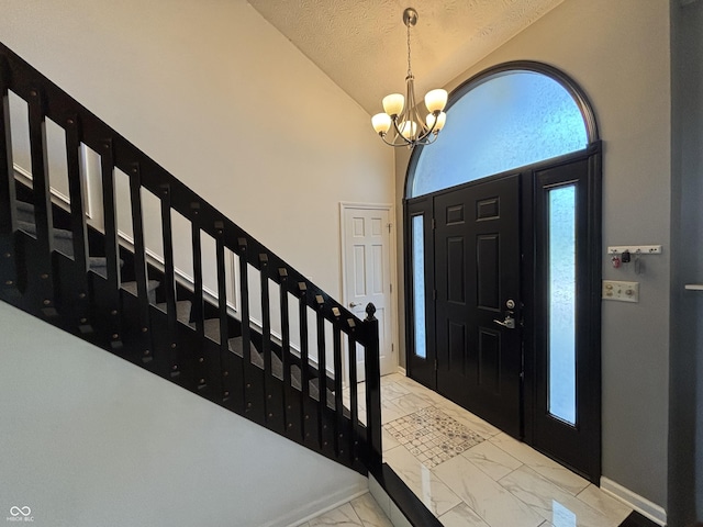 11720 Grenadier Ln, Indianapolis, IN 46229 - foyer entrance featuring marble finish floors, stairway, lofted ceiling, a chandelier, and baseboards