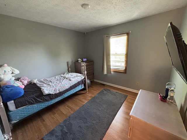 11720 Grenadier Ln, Indianapolis, IN 46229 - bedroom with wood finished floors, baseboards, and a textured ceiling